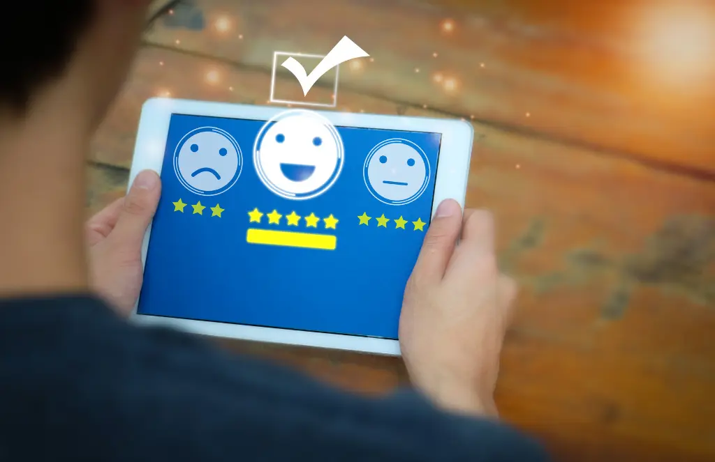 A man using tablet for check mark icon and face emoticon smile on dark background customer service review dashboard