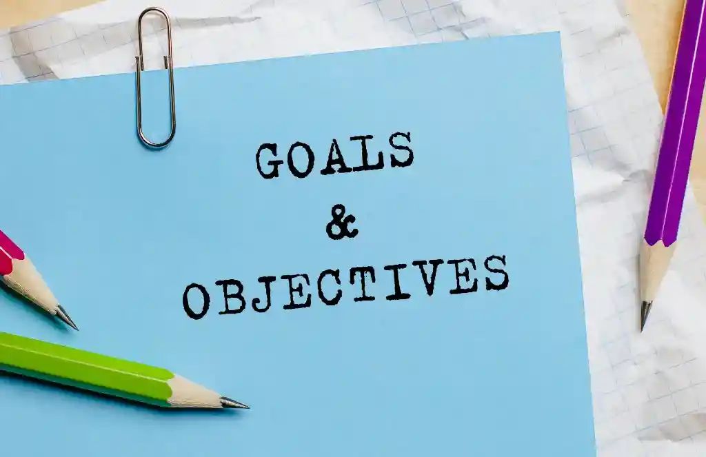 Goals objectives text written on a paper with pencils in office