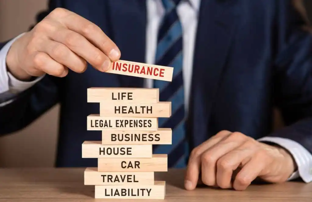 INSURANCE concept. Stack of wooden blocks with words: life, health, legal expenses, business, house, car, travel, liability