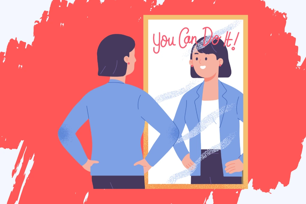 A girl with, wearing a blue jacket, stands with hands on hips, looking into a mirror. The reflection shows them smiling. The words You Can Do It! are written on the mirror